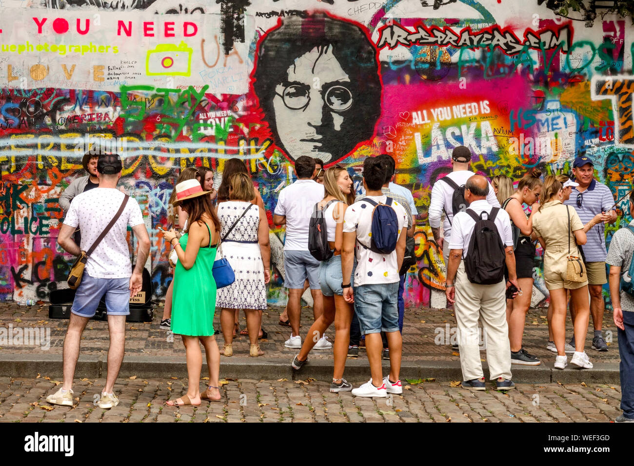 I turisti di fronte al muro di John Lennon di Praga gruppo turistico di persone visitano la città di Praga Repubblica Ceca Foto Stock