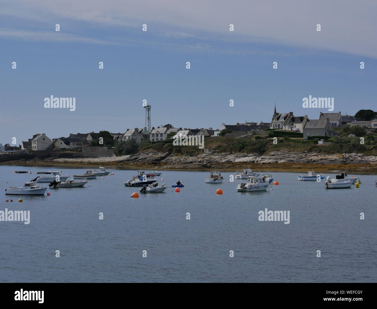 L'île de molène et son merveilleux port et ses bateaux multicolori et ses quais en granit et onu banc bleu et blanc et l'île prise depuis le grandi Foto Stock