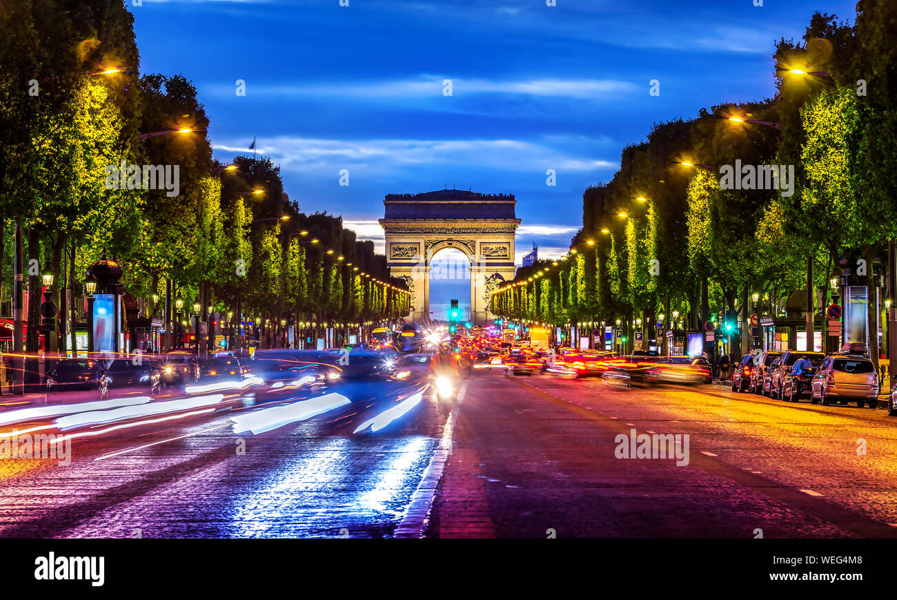 Illuminata Champs Elysee e vista di Arc de Triomphe in serata parigina, Francia Foto Stock