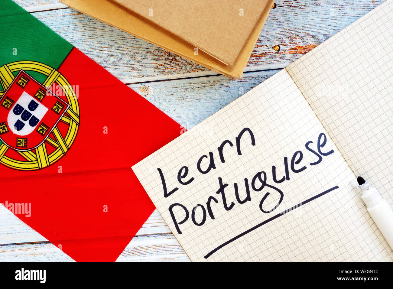 Imparare la lingua portoghese concetto. Bandiera e i notebook. Foto Stock