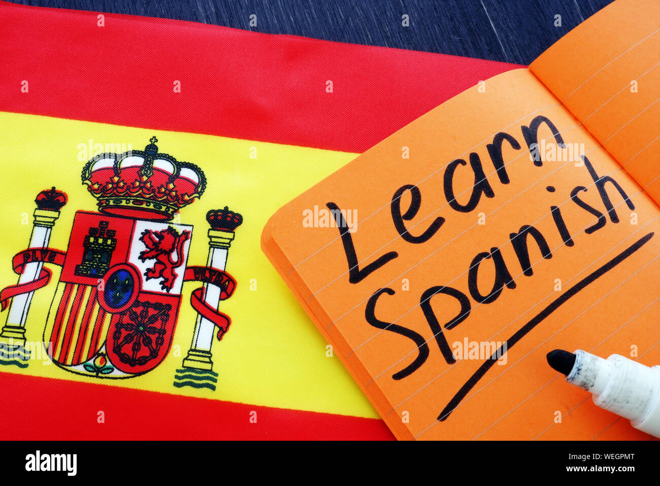 Imparare Spagnolo scritto nel notebook con bandiera. Foto Stock