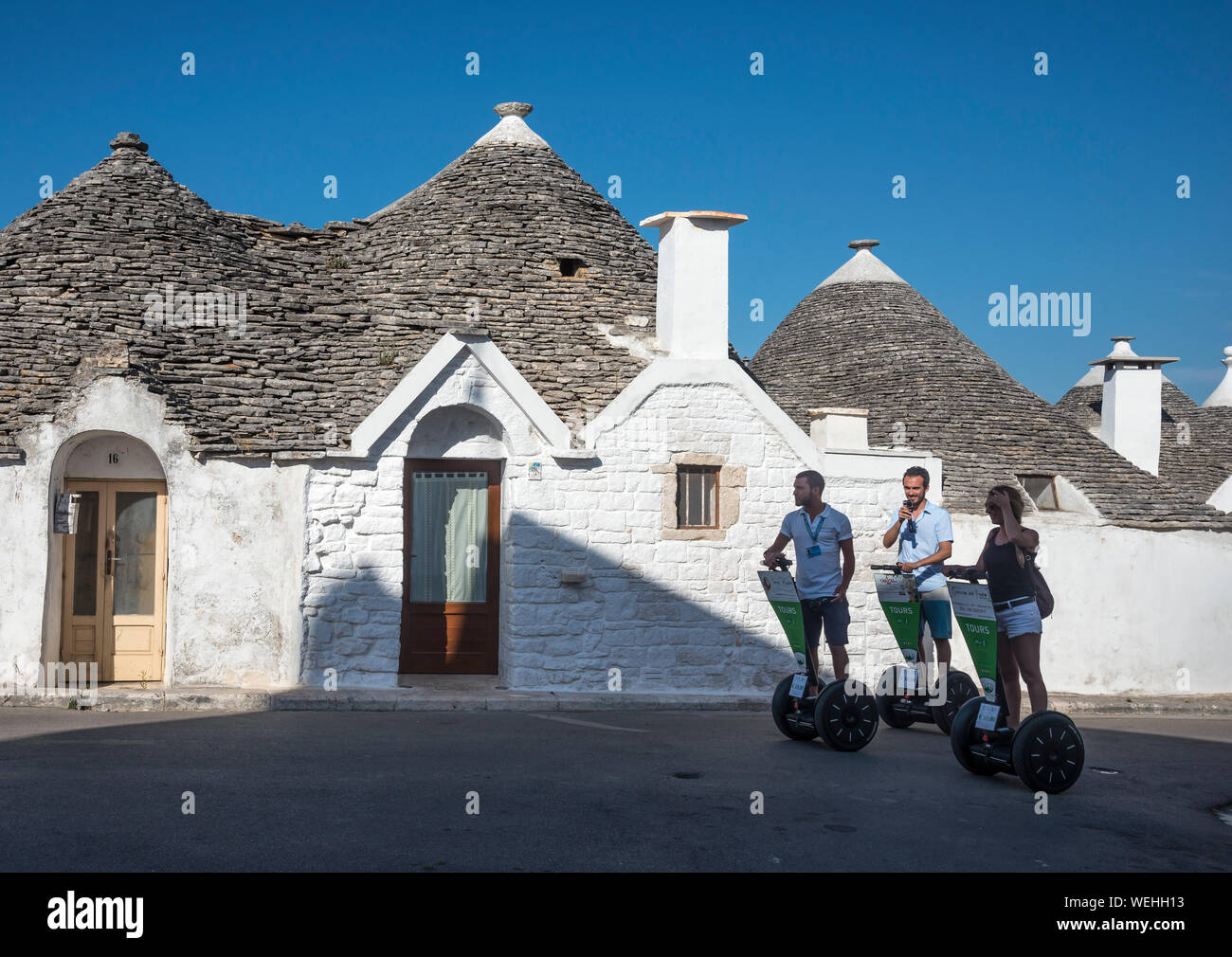 Segway tour attorno alla tradizionali Trulli case nella città di Alberobello Puglia, Italia. Foto Stock