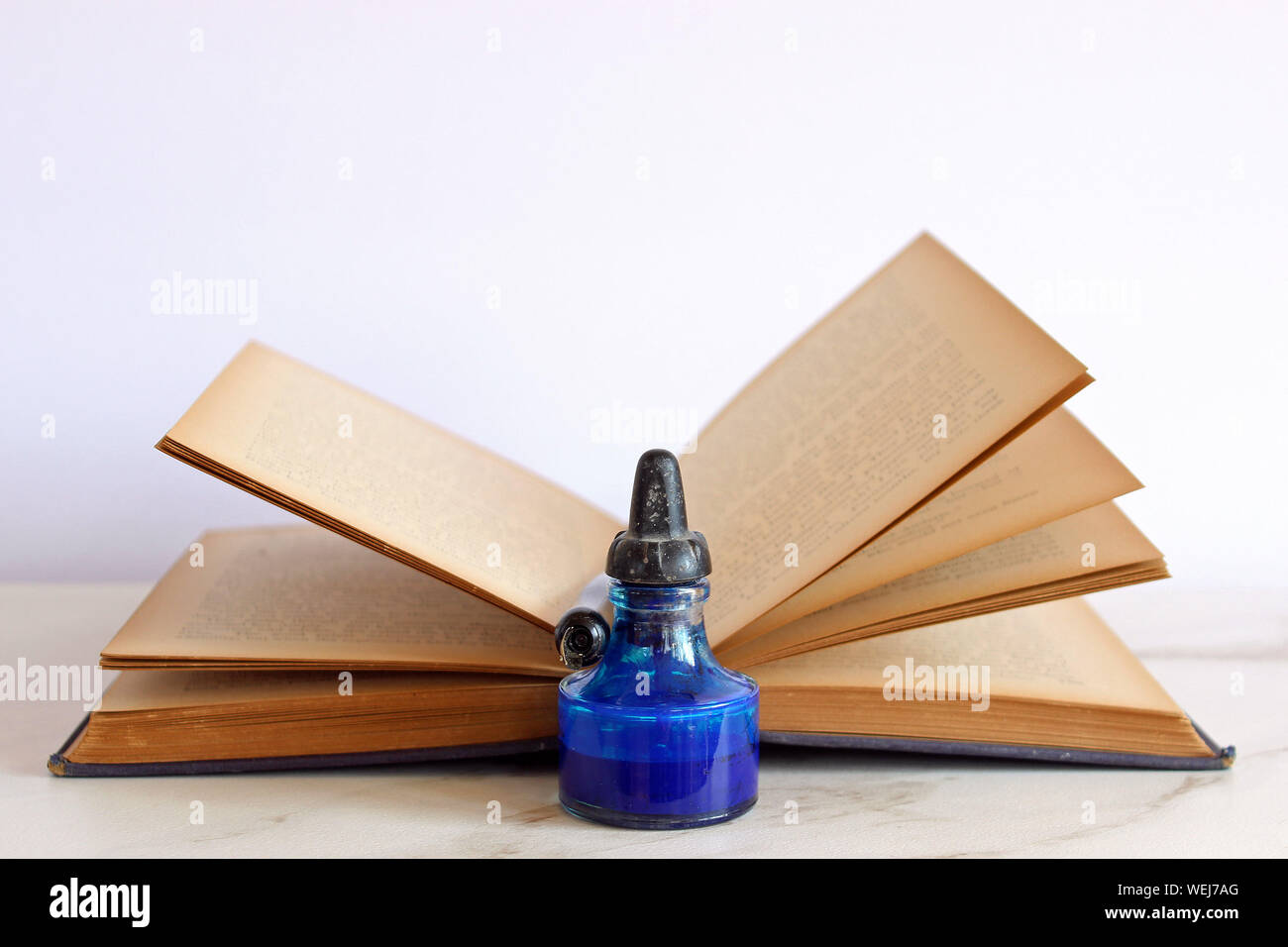 Close-up della bottiglia di inchiostro e penna stilografica su Open vecchio  libro contro uno sfondo bianco Foto stock - Alamy