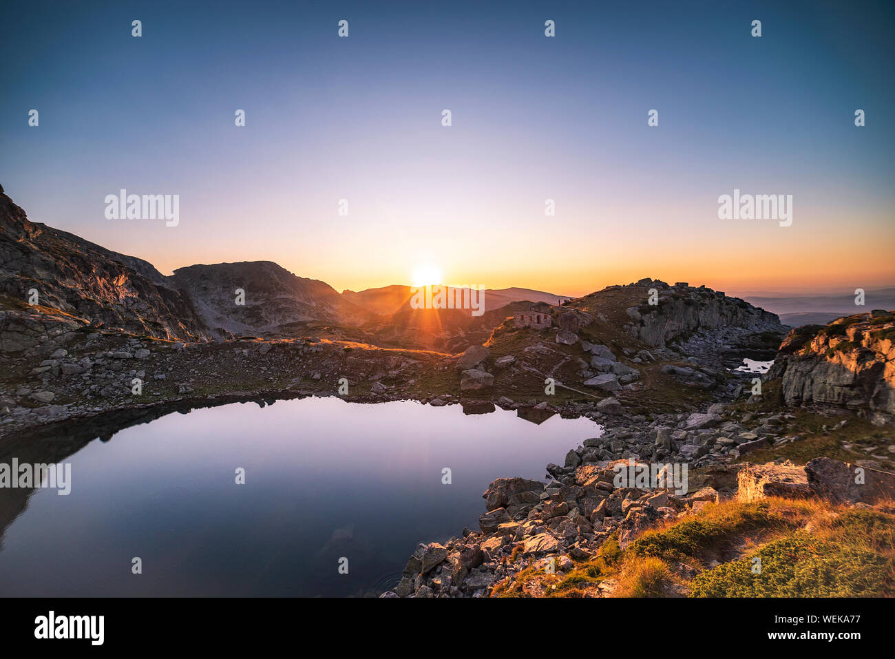 Panorama mozzafiato del lago spaventoso durante la calda estate tramonto, montagna Rila national park, Bulgaria Foto Stock