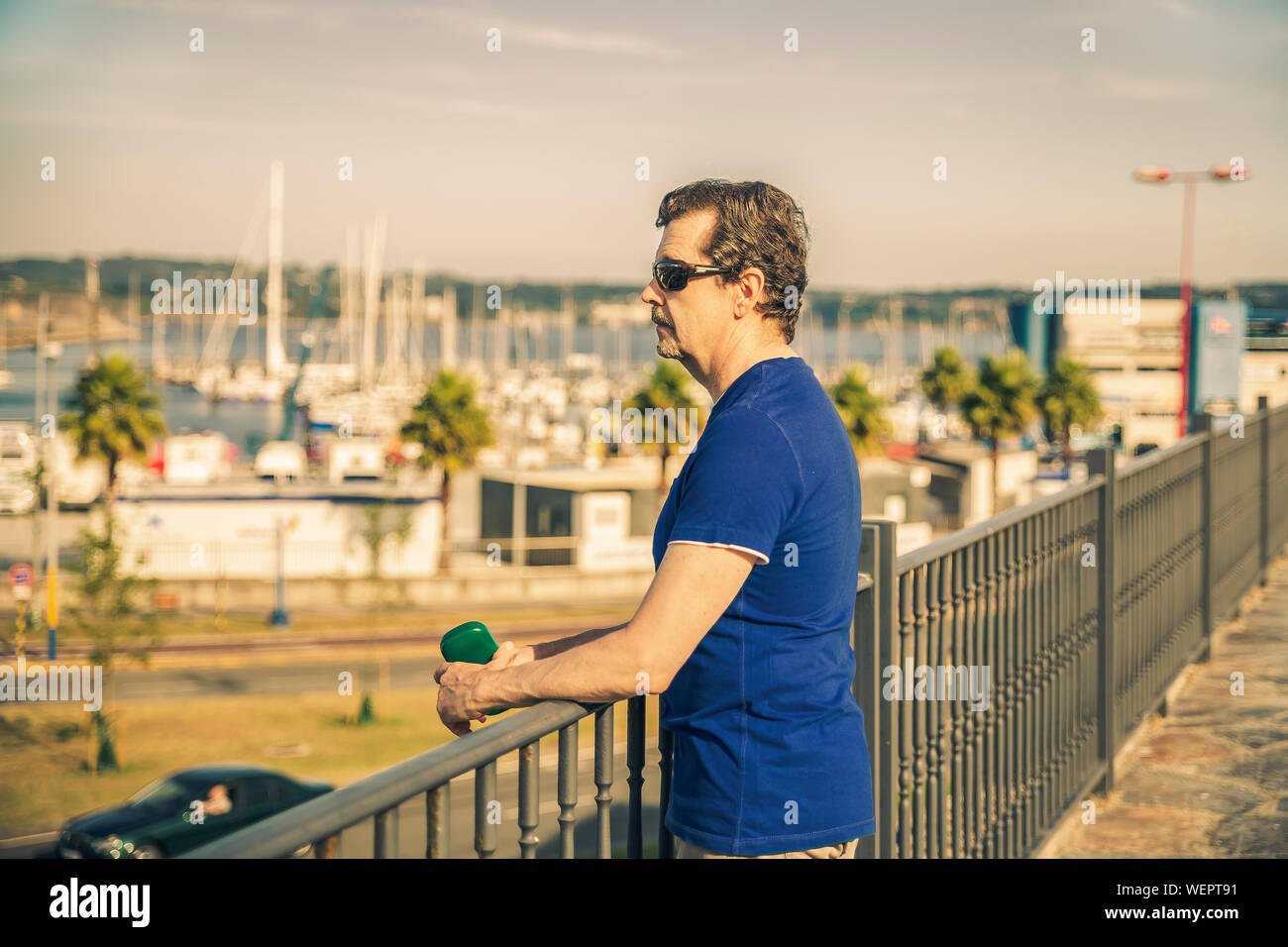 Uomo in piedi e pensare in futuro appoggiato su di una ringhiera Foto Stock