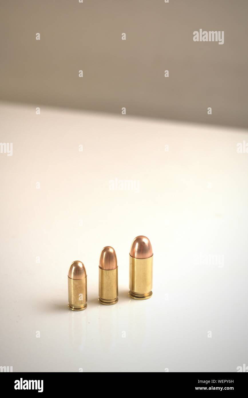 Tre proiettili di calibri diversi su una superficie bianca. Da sinistra a destra: .380 FMJ auto 9x19mm FMJ .45 FMJ automatica Foto Stock
