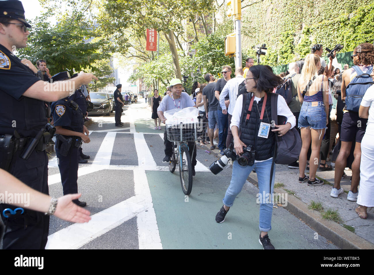 New York, New York, Stati Uniti d'America. Il 30 agosto, 2019. New York poliziotto J. NOVA tenta di avvertire un New York City fotografo di essere colpito da una moto mentre si tenta di mantenere la pista ciclabile chiaro per bike rider che raramente battuta di arresto per i pedoni in pista ciclabile. Almeno 19 ciclisti sono stati colpiti e uccisi da automobilisti questo anno secondo rapporti di NYPD. Credito: Brian ramo Prezzo/ZUMA filo/Alamy Live News Foto Stock