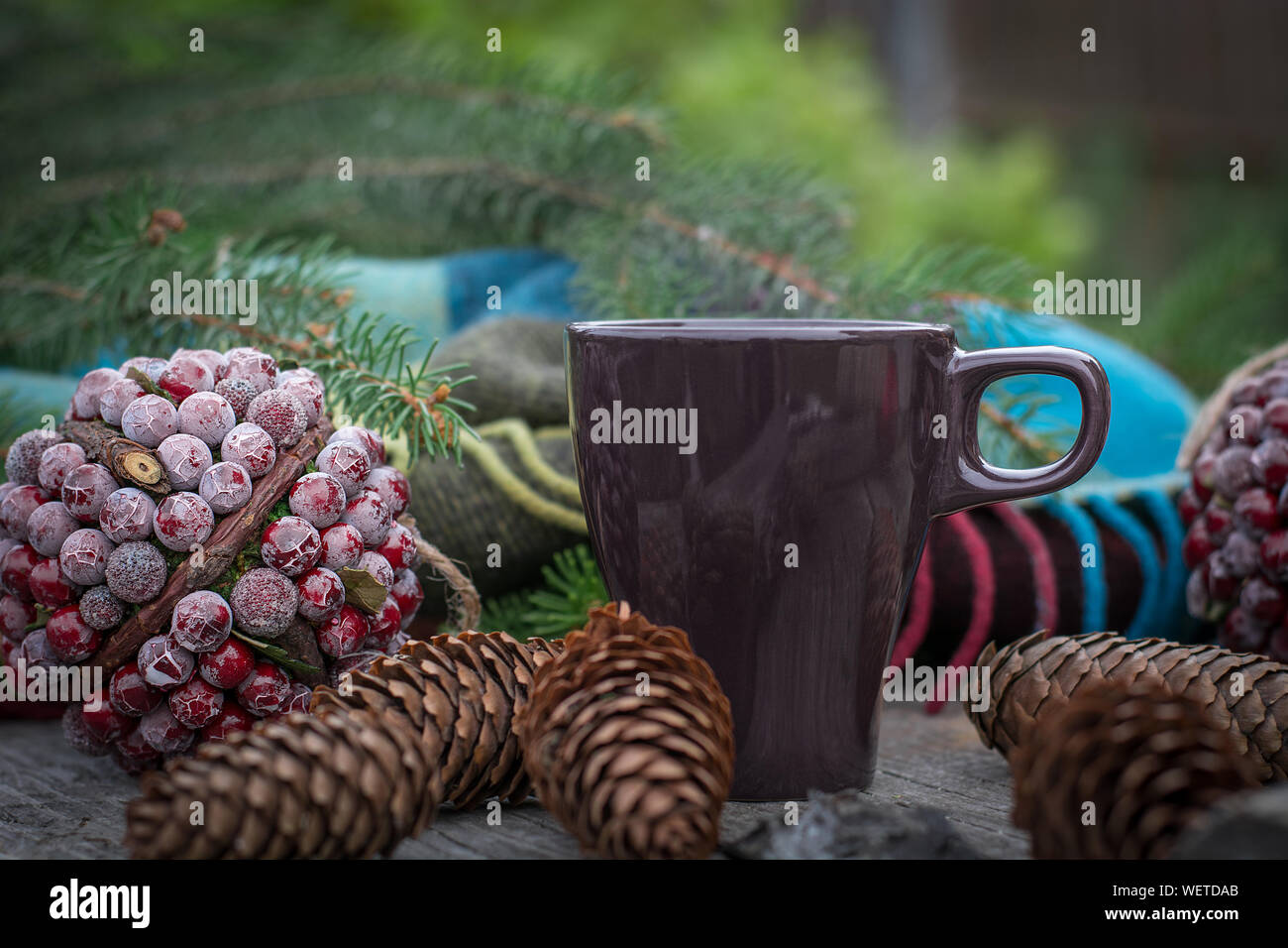 Rientrano ancora in vita con tazza di tè caldo su tavola in legno rustico. Il decor di coni, calde coperte, Abete rami. Il tempo di Natale. Foto Stock