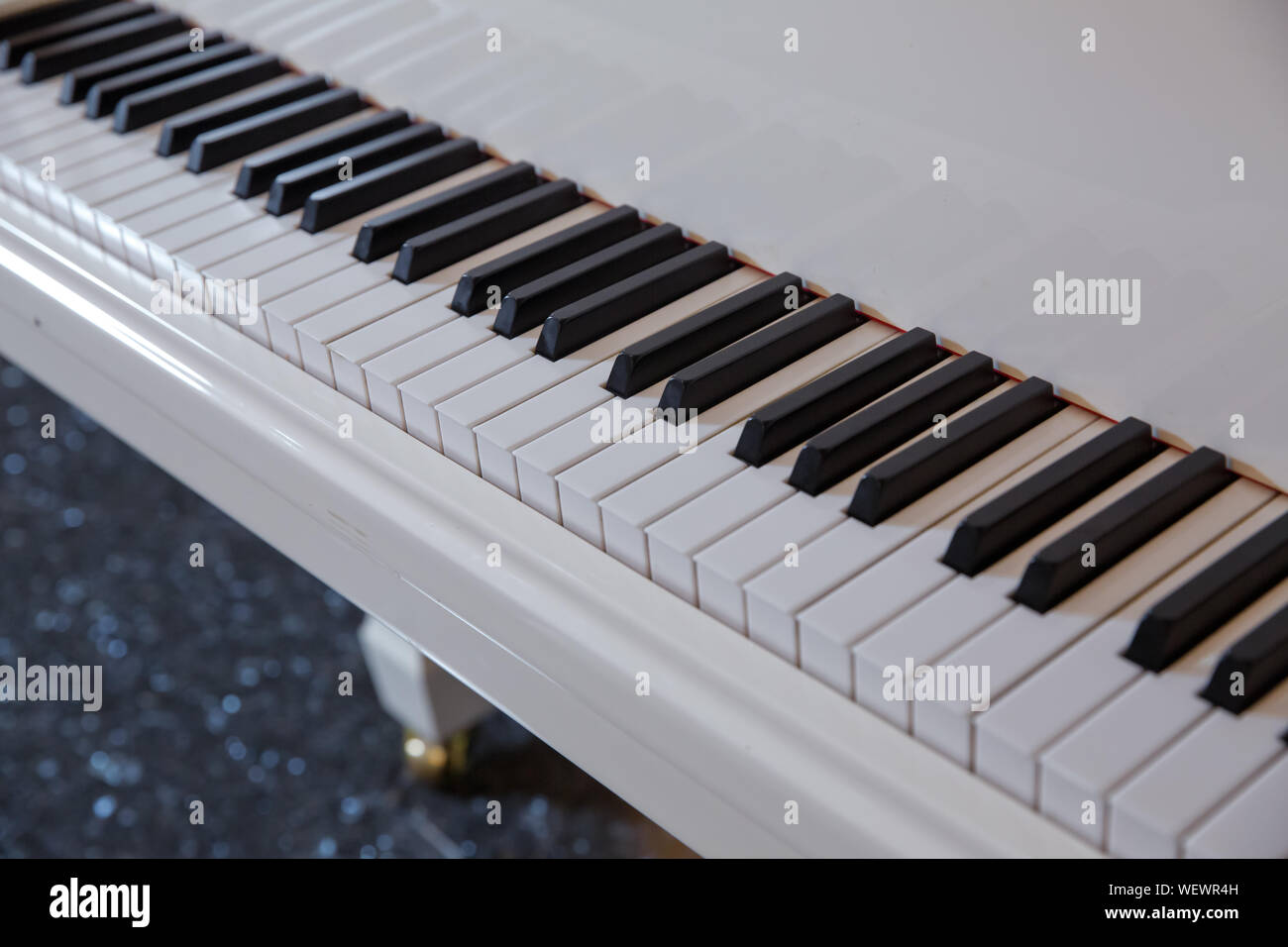 Grand piano tastiera con nero lucido e tasti bianchi come una musica di sottofondo in ampia panoramica formato banner, selezionata la messa a fuoco e profondità di campo ridotta Foto Stock