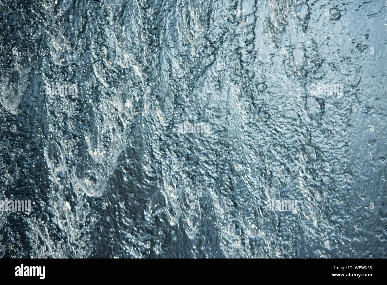 Tutti blu su sfondo muro di acqua con acqua di streaming e di bolle Foto Stock