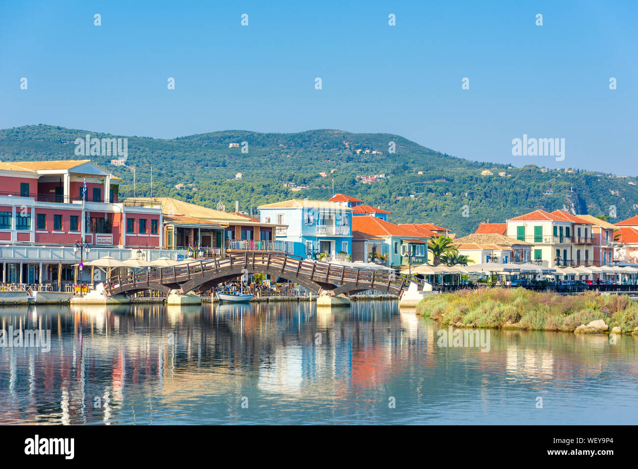 (Lefkada Lefkada) città, con una vista straordinaria al piccolo porticciolo per le imbarcazioni da pesca con il bel ponte di legno e il lungomare, isola del Mar Ionio, Grecia Foto Stock