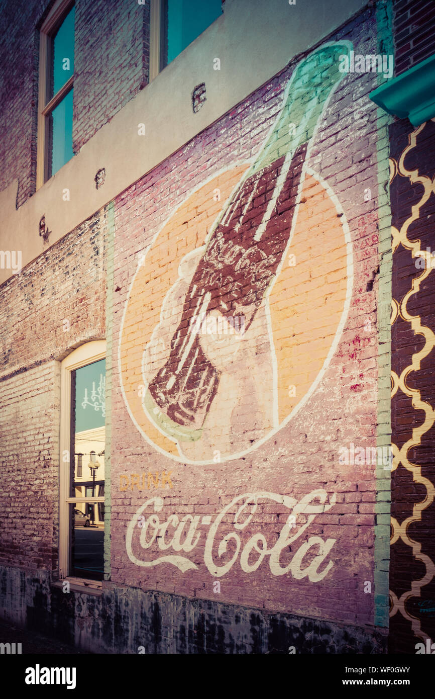 Un vecchio annuncio vintage per la Coca Cola di fading su un vecchio muro di mattoni di un edificio in downtwown Tupelo, Mississippi, STATI UNITI D'AMERICA Foto Stock
