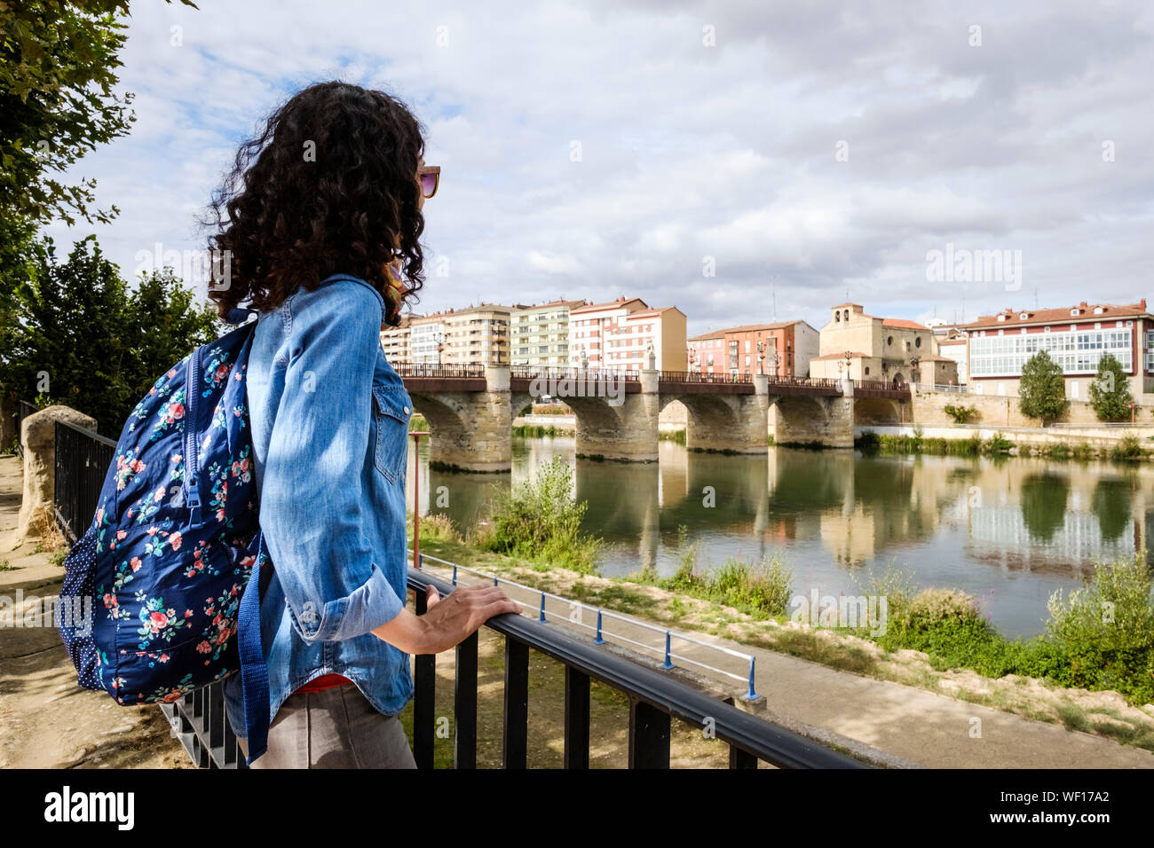 Lei sta guardando lo storico ponte di Carlos III sul fiume Ebro in Miranda del Ebro, provincia di Burgos, Spagna Foto Stock