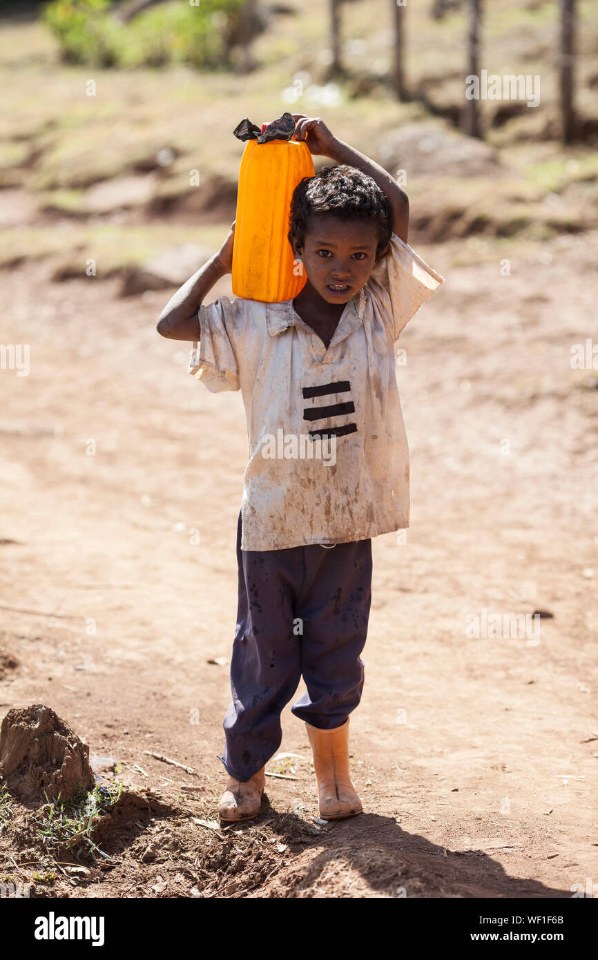 OROMIA, ETIOPIA-aprile 21, 2015: bambino non identificato porta acqua da una sorgente a casa sua in Oromia, Etiopia Foto Stock