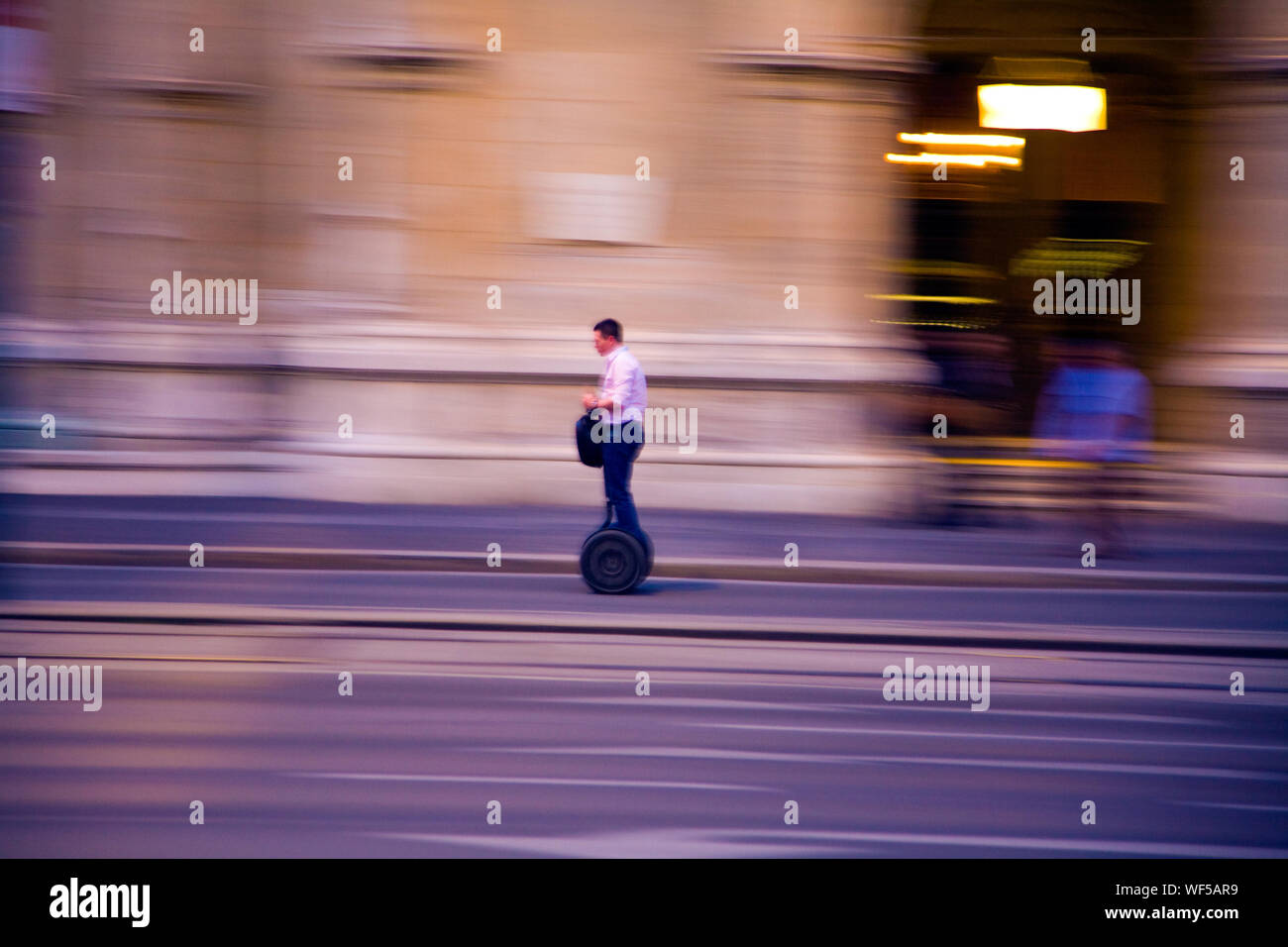 Uomo che cavalca Segway lungo una strada di Vienna in Austria. Foto Stock