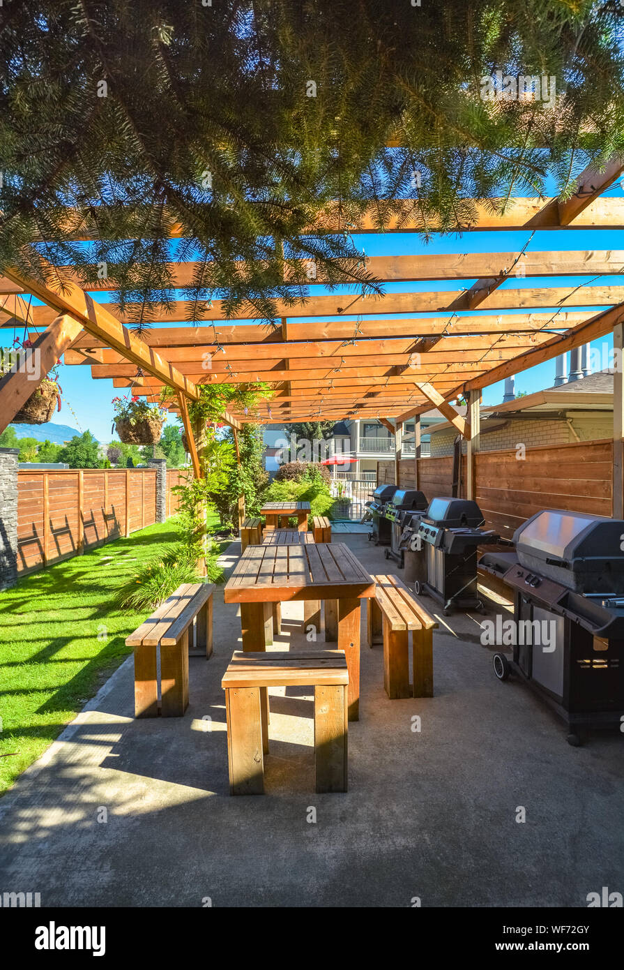 Barbecue e zona pic-nic di hotel con fila di tavoli e barbecue sotto il  portico Foto stock - Alamy