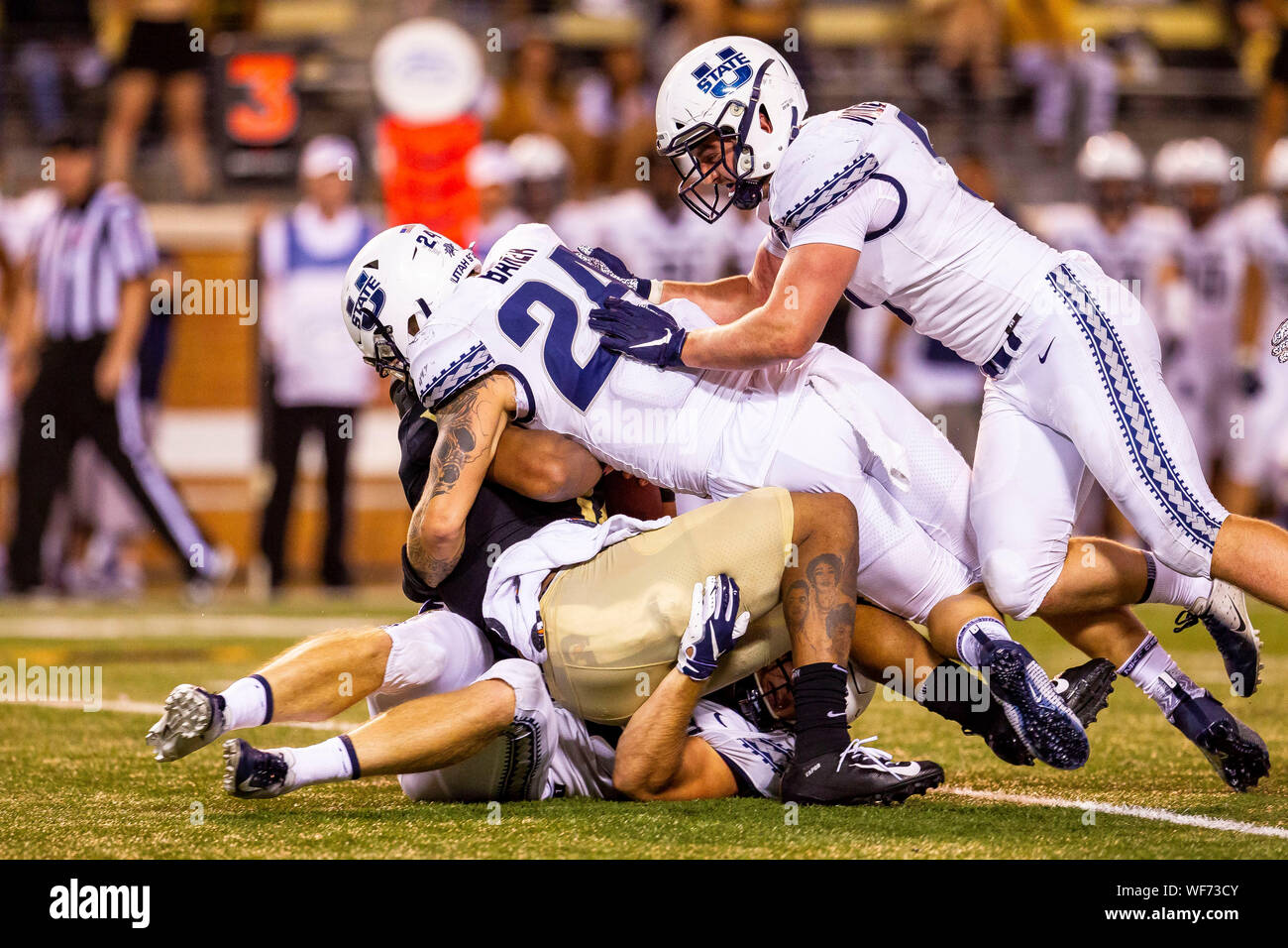 Agosto 30, 2019: Wake Forest Demon diaconi quarterback Jamie Newman (12) viene saccheggiata da Utah State Aggies difensivo fine Dalton Baker (24) nel quarto trimestre del NCAA matchup a BB&T Campo in Winston-Salem, NC. (Scott Kinser/Cal Sport Media) Foto Stock