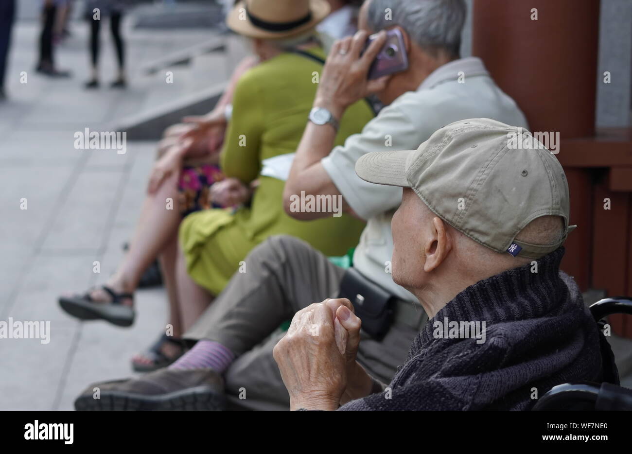 Montreal, Quebec / Canada - Luglio 24, 2019: Anziani uomo cinese guardando la generazione più giovane durante il loro esercizio di gruppo in Chinatown, Montreal Foto Stock