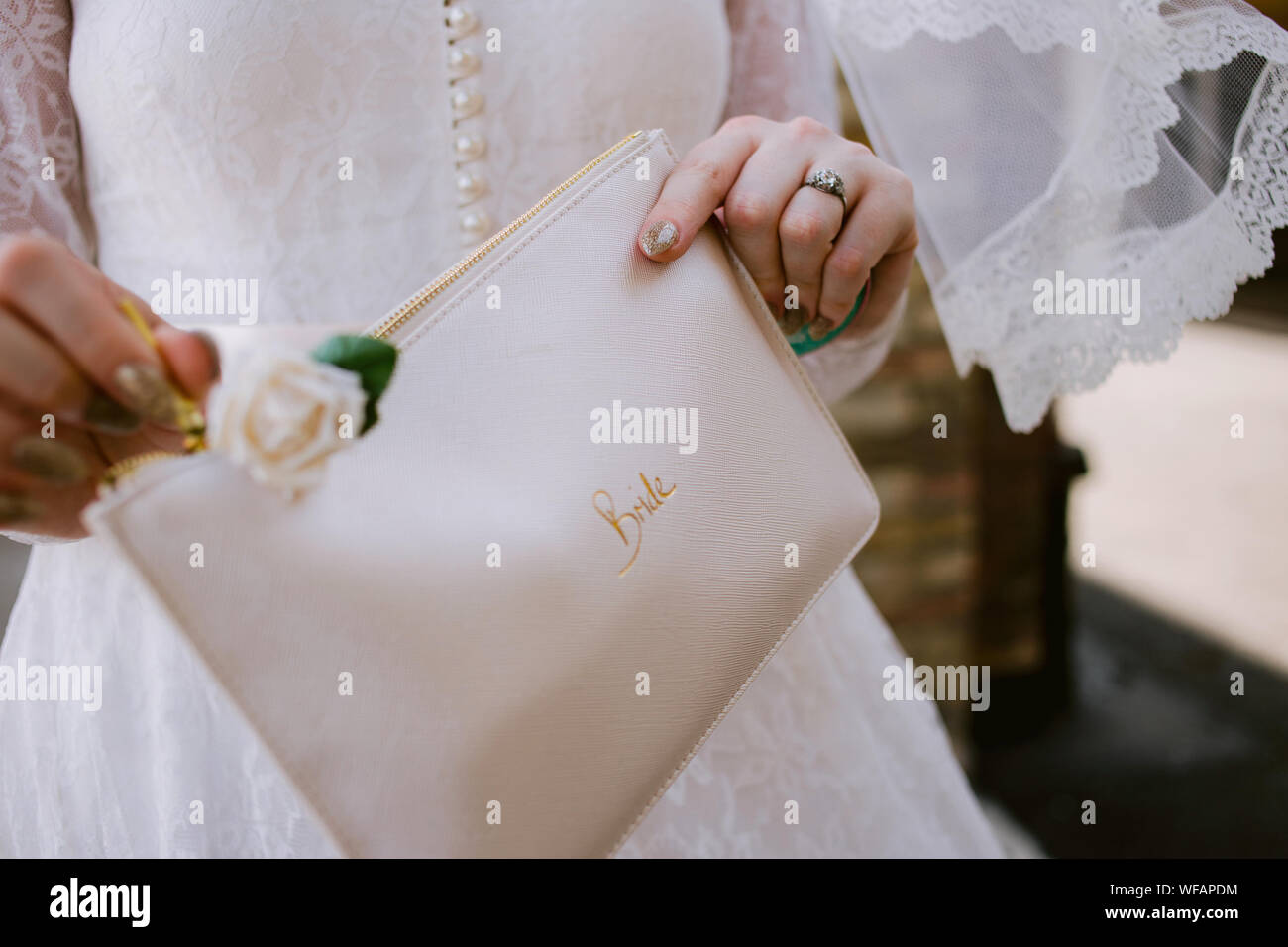 dettaglio della sposa il suo giorno di nozze tenendo una borsa con la sposa scritta su di esso Foto Stock
