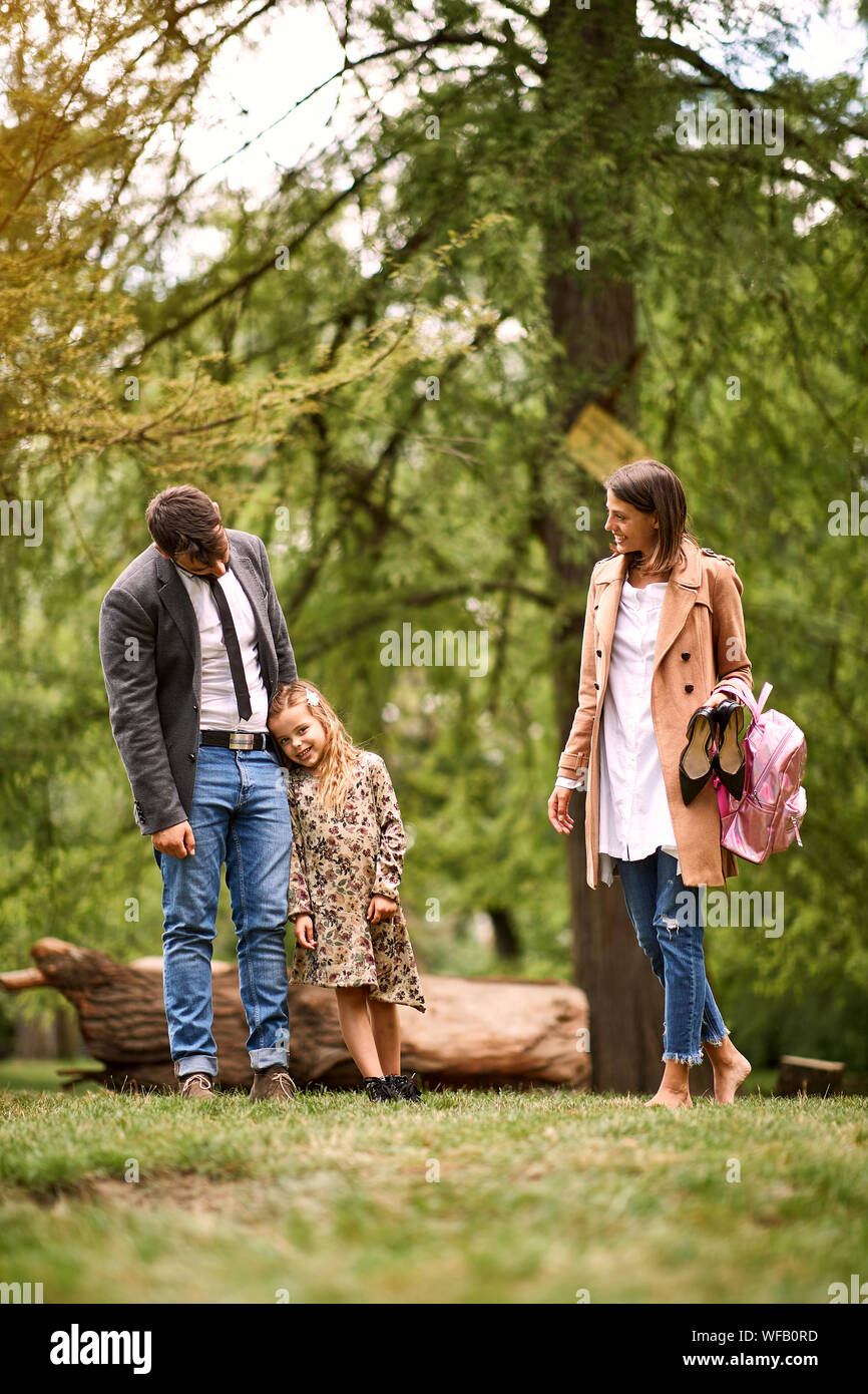 Felice famiglia giovane nel parco dopo la scuola e il lavoro di business Foto Stock