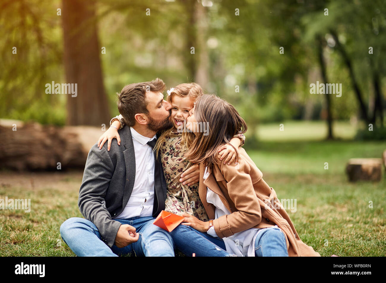 Infanzia felice - i genitori di baciare la loro bambina bambino Foto Stock