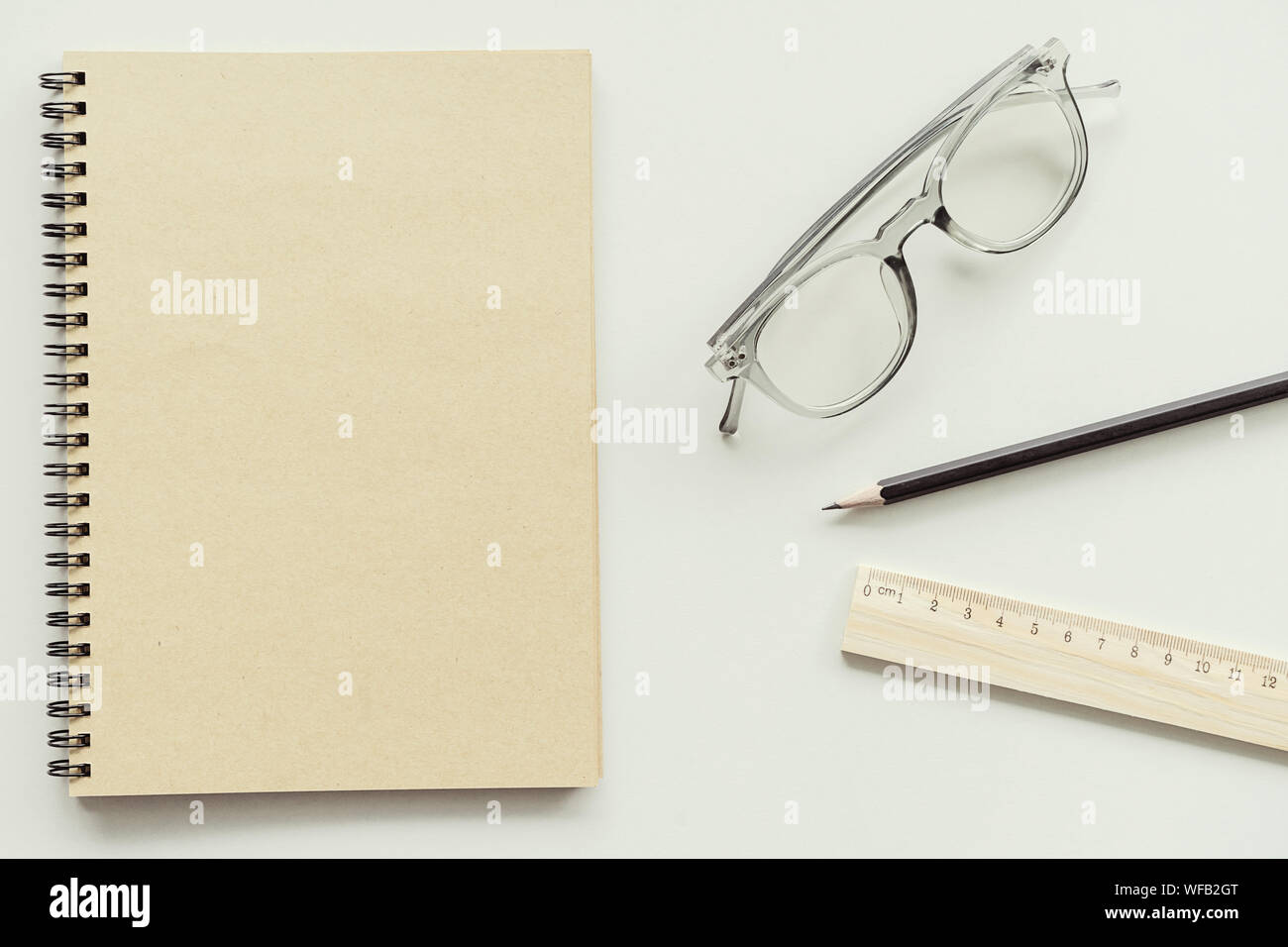 Elevato angolo di visione del Libro di occhiali con la matita e il righello su sfondo bianco Foto Stock