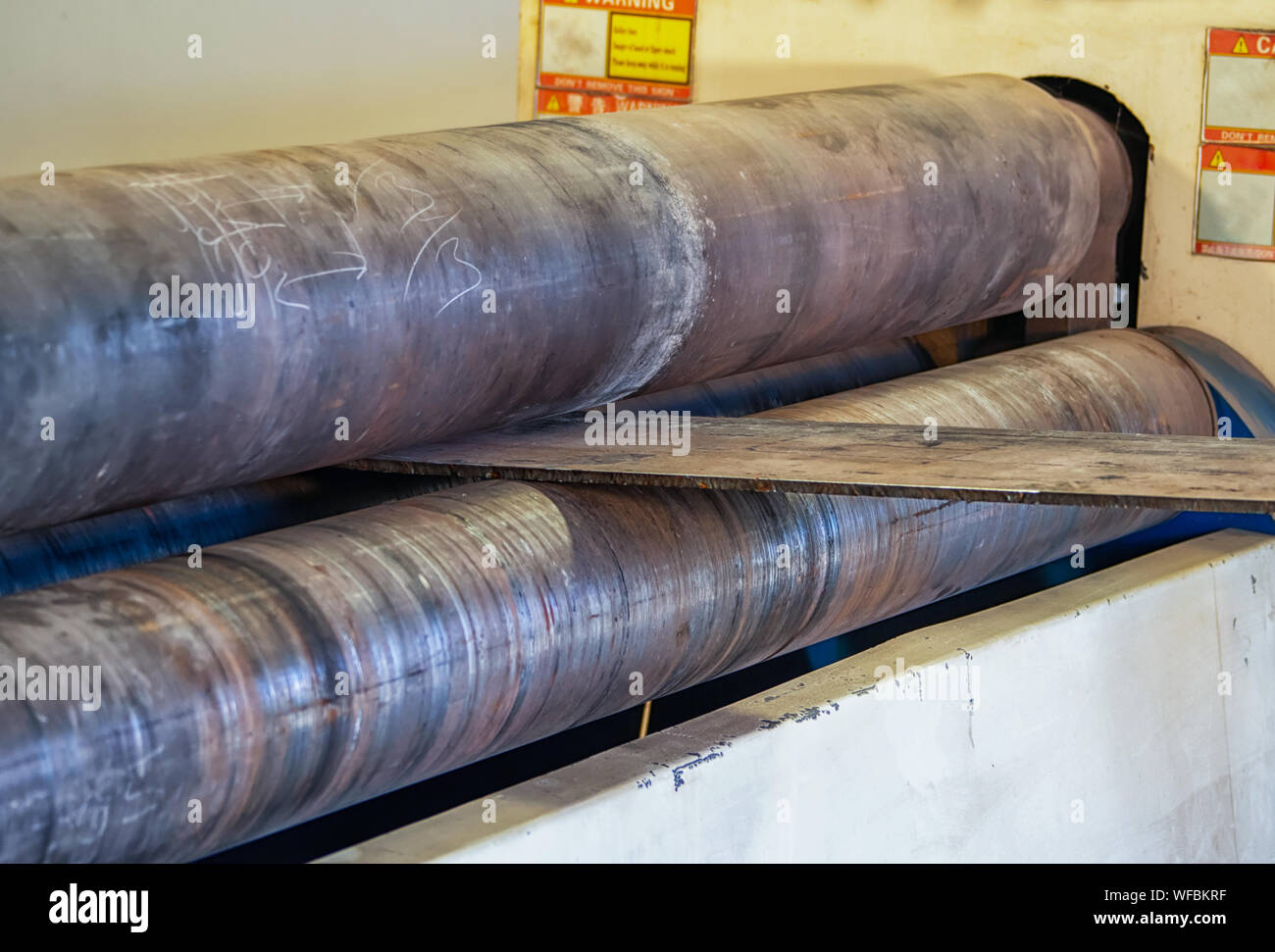 Lavoratore che utilizza una macchina rotolatrice in un'officina del Botswana Foto Stock