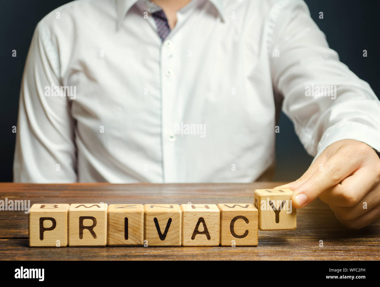 Imprenditore mette dei blocchi di legno con la parola privacy. Mantenendo le informazioni segrete circa una persona della personalità o attività e la condizione finanziaria. Saf Foto Stock