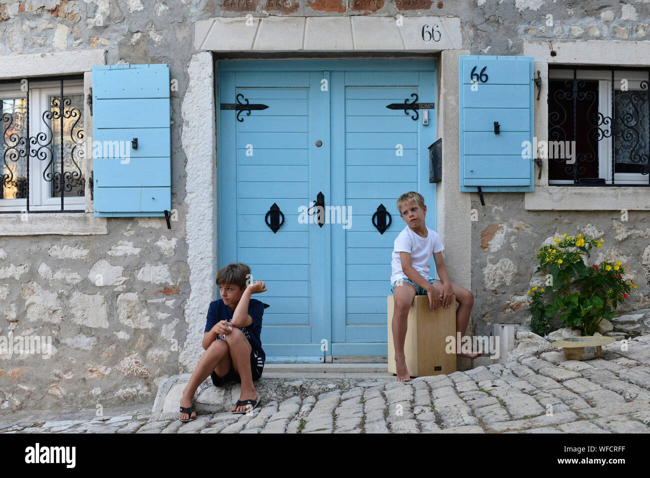 Due ragazzi locali in giro davanti alla loro casa per le strade della città di Rovigno, Istria, Croazia, Europa. Foto Stock