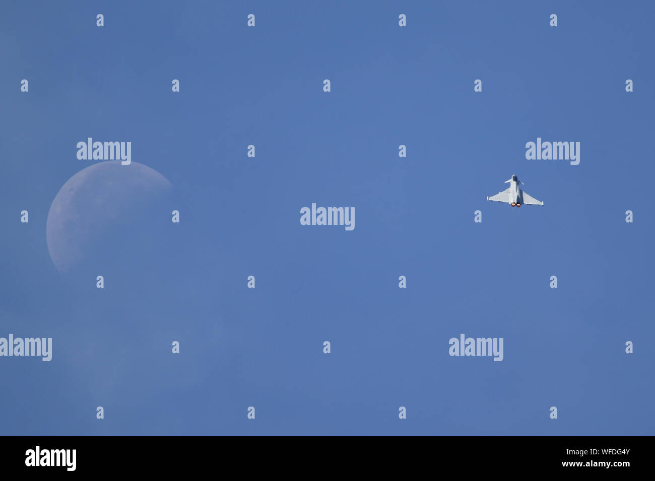 RAF Typhoon arrampicata fuori in un cielo blu con la luna. Foto Stock