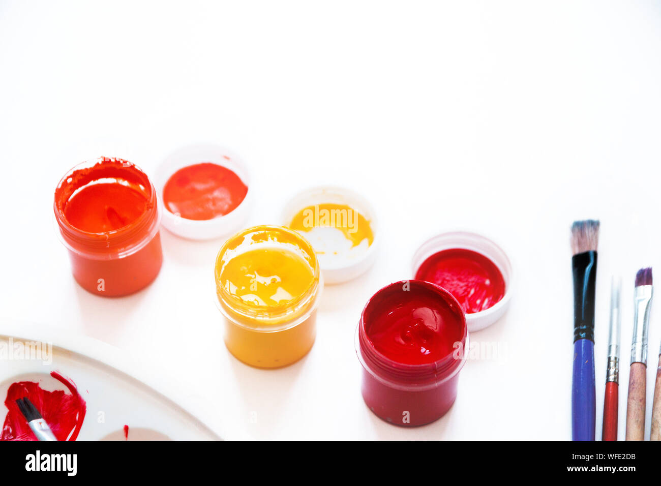 Brillanti colori autunnali, vernici acriliche, i pennelli e la tavolozza dei colori su sfondo bianco, spazio piatto o strato di testo. Concetto torna a scuola. Close-up, copia di spazio, Foto Stock