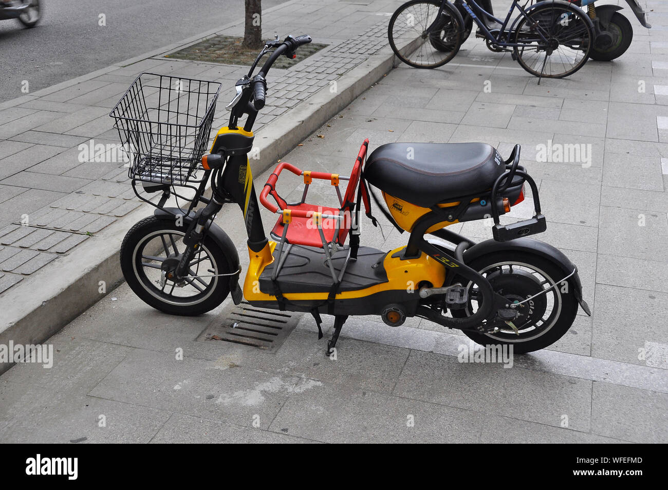 Un'e-bike in Cina con un interessante aggiunta di un seggiolino per bambini. Foto Stock