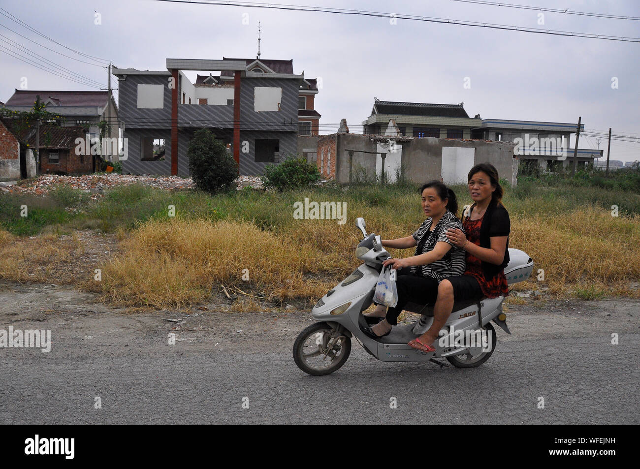 Il cinese e-bike rider viaggiare attraverso una zona che viene riproposto, Nantong Cina Foto Stock
