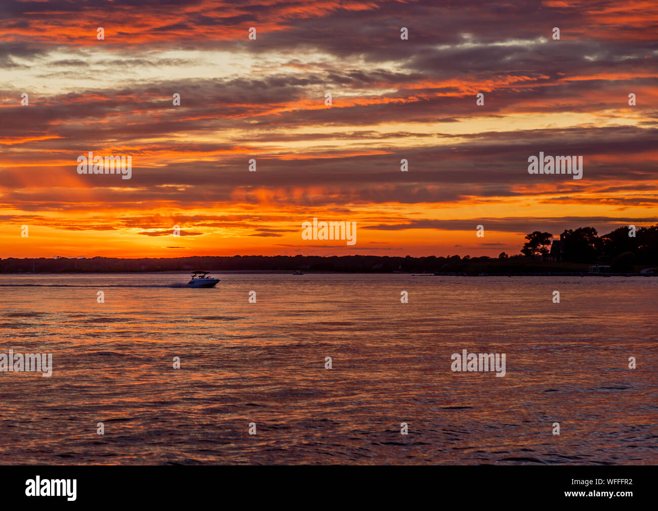 Un tramonto da favola con un power boat in corso e forcella del nord in background Foto Stock