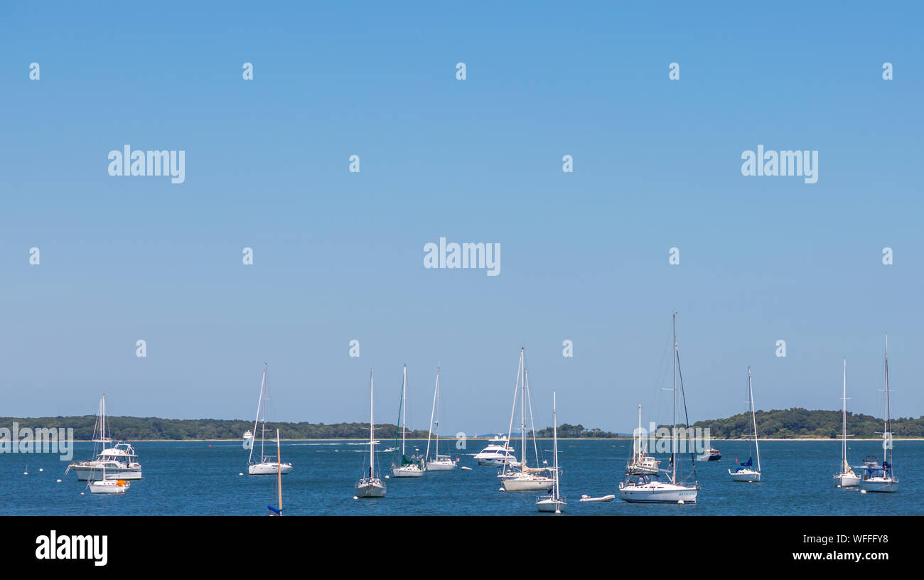Barche su ormeggi in Sag Harbor, NY con Shelter Island in background. Foto Stock
