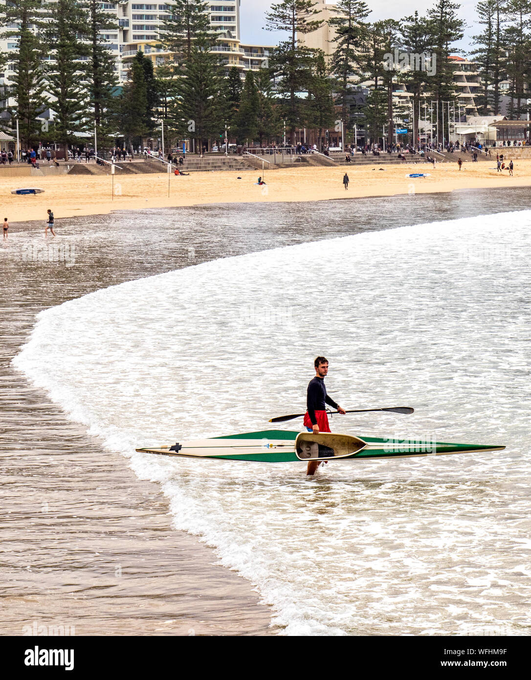 L'uomo entra in mare con il kayak e pagaia a Manly Beach Sydney NSW Australia. Foto Stock