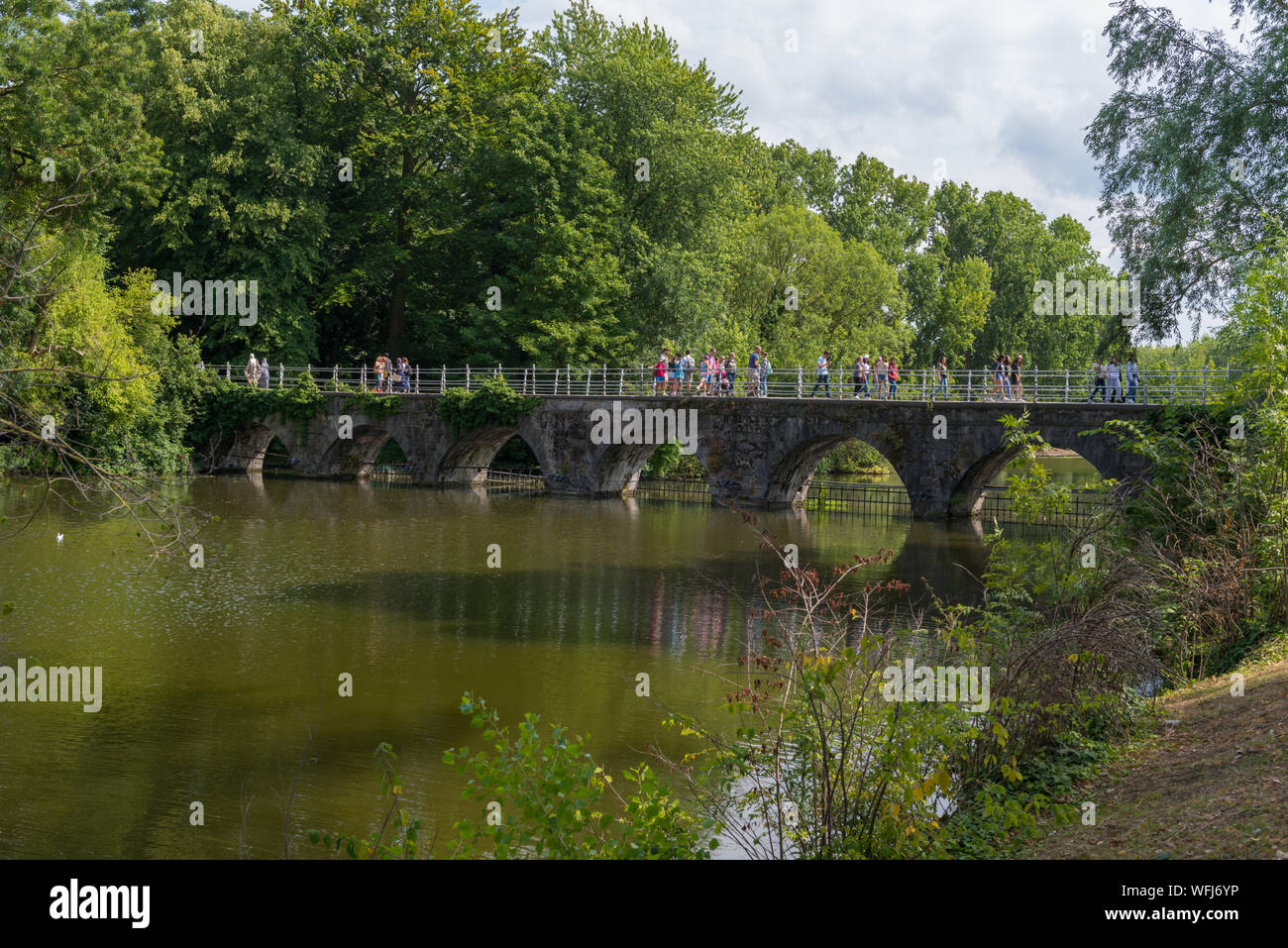 La gente sul ponte sopra il Minnewater (Lago di amore) in il Minnewaterpark a Bruges, Belgio Foto Stock