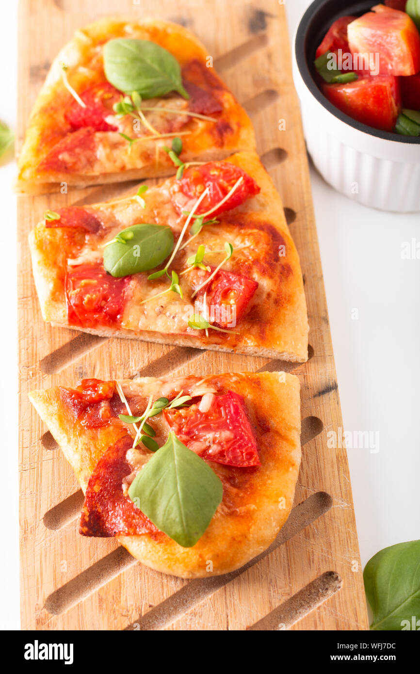Concetto di cibo organico in casa la pizza con pomodoro, basilico e prosciutto con spazio di copia Foto Stock