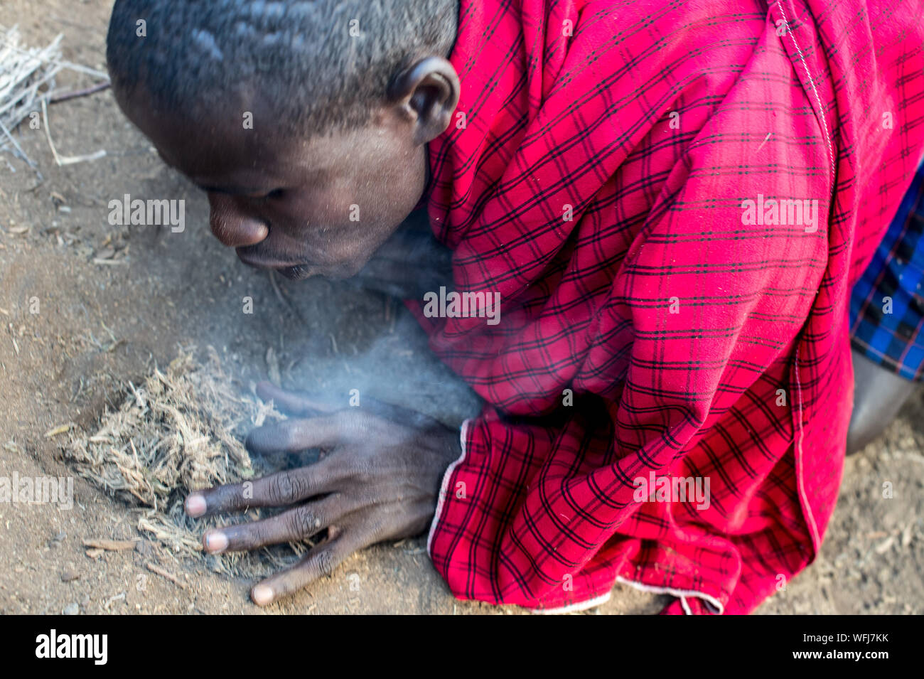 Tribù Masai man start incendio con bastoni di legno. Villaggio Tradizionale all'interno di vil Amboseli National Park, Kenya, Africa Foto Stock