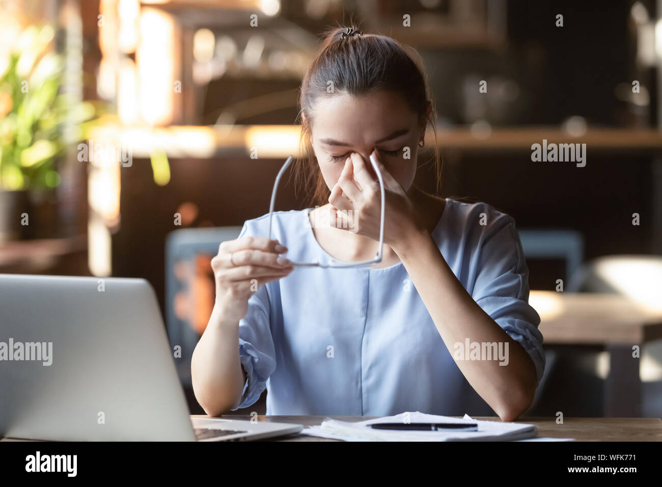 Sottolineato stanco studentessa holding bicchieri sensazione di affaticamento della vista mal di testa Foto Stock