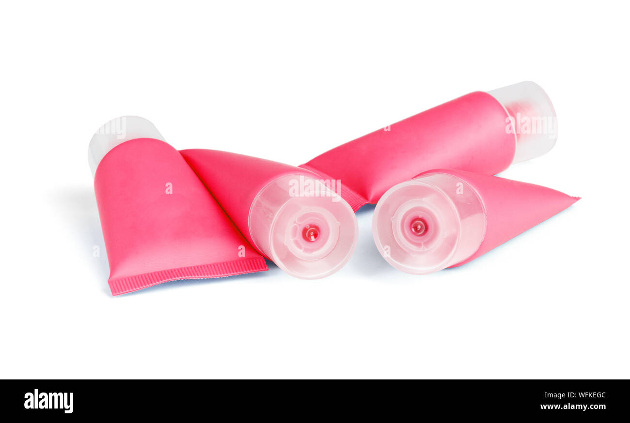 Rosso di tubi in plastica per prodotti cosmetici giacente su sfondo bianco Foto Stock