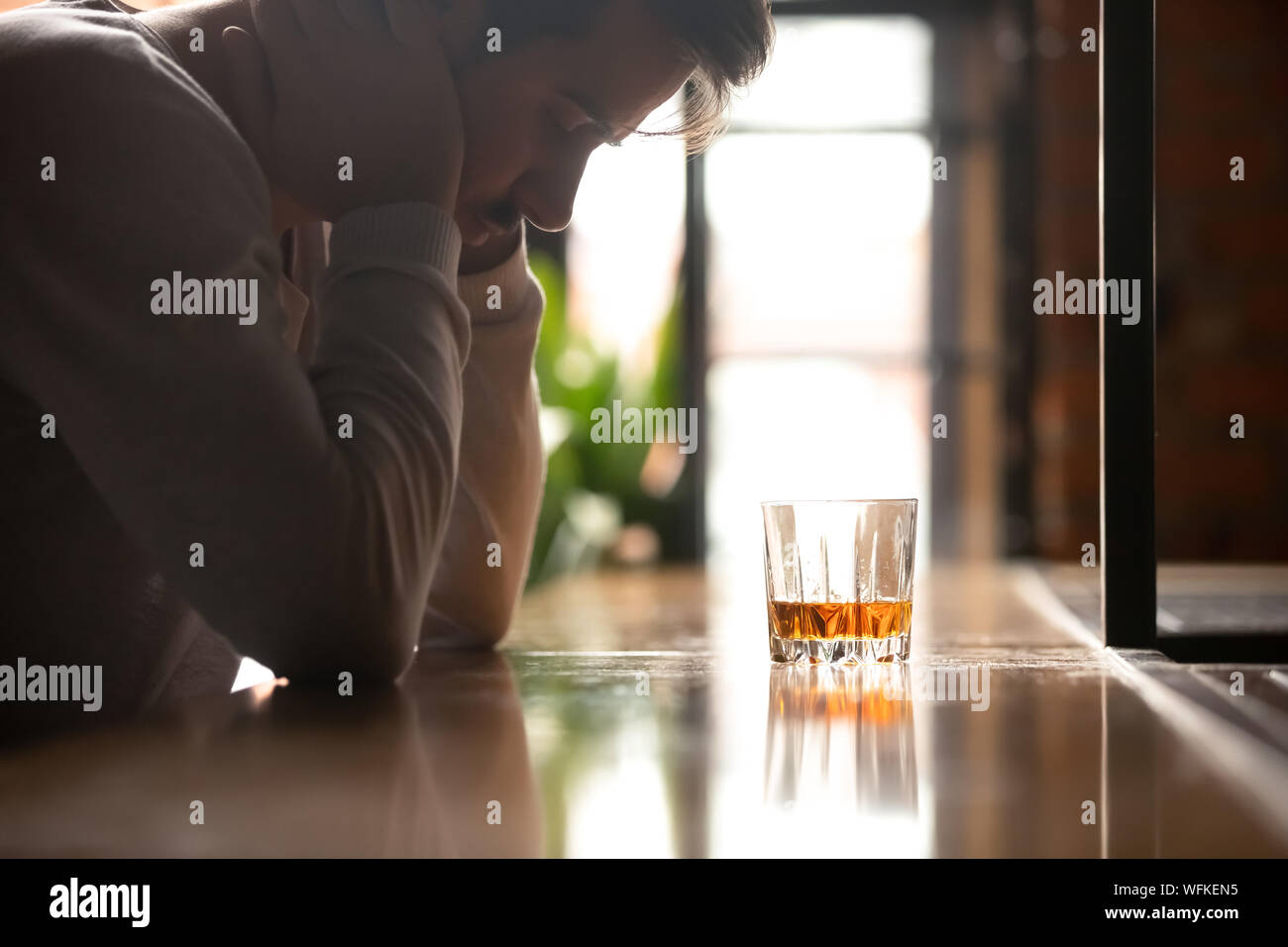 Premuto triste ubriaco addicted uomo bere whisky da solo in bar Foto Stock