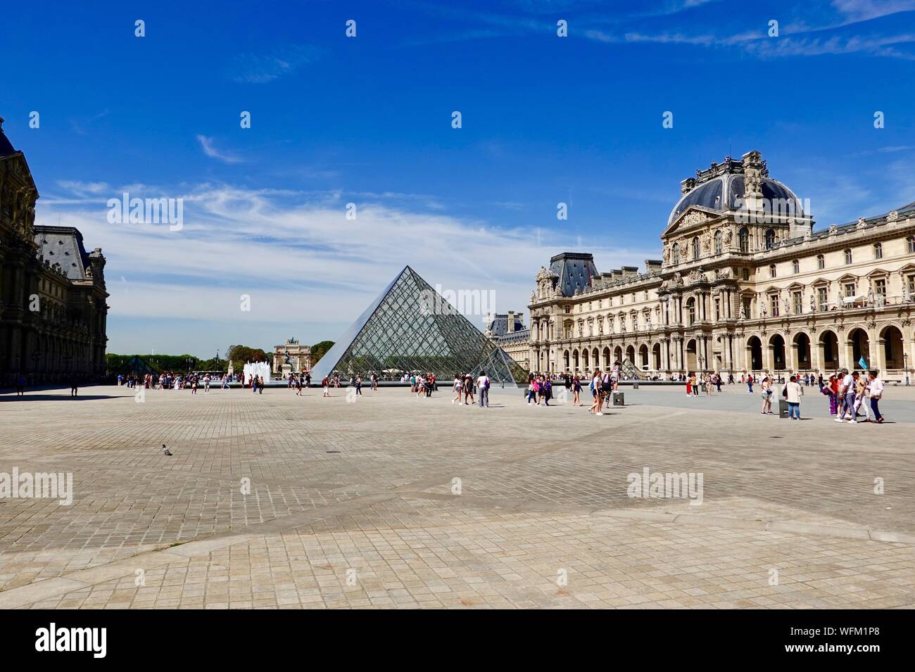 La piramide del Louvre con persone, tarda estate, Parigi, Francia Foto Stock