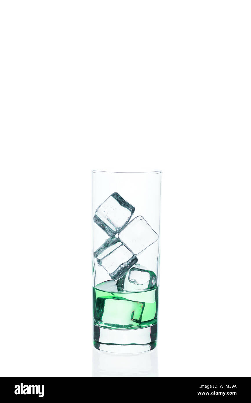 Green drink con cubetti di ghiaccio in un bicchiere su sfondo bianco. Refrigerate cocktail esotici. Tonic liquido direttamente dalla barra. Foto Stock