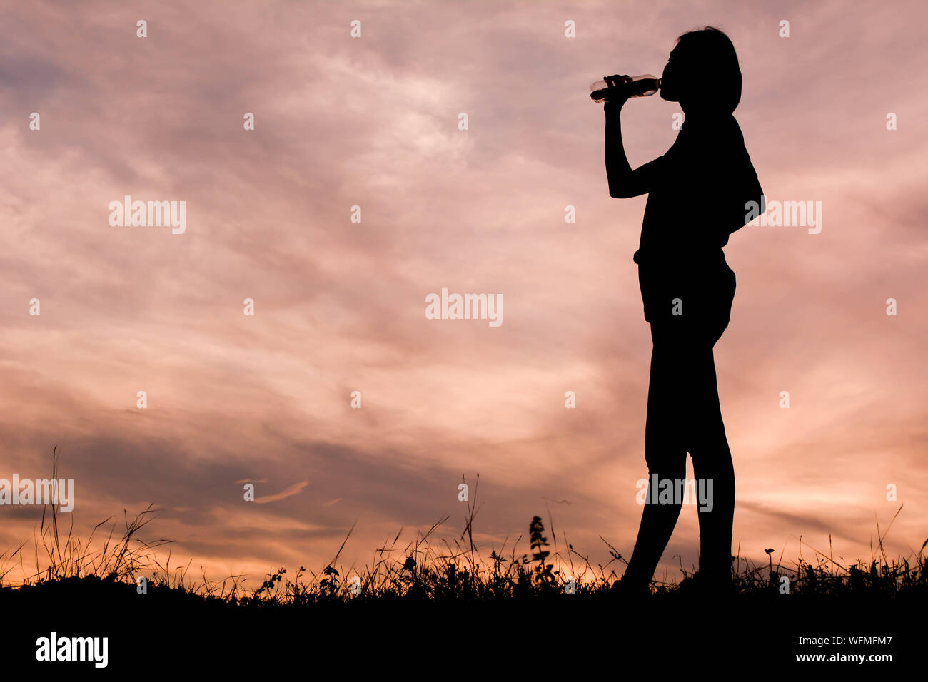 Silhouette di persona in piedi contro il cielo drammatico Foto Stock