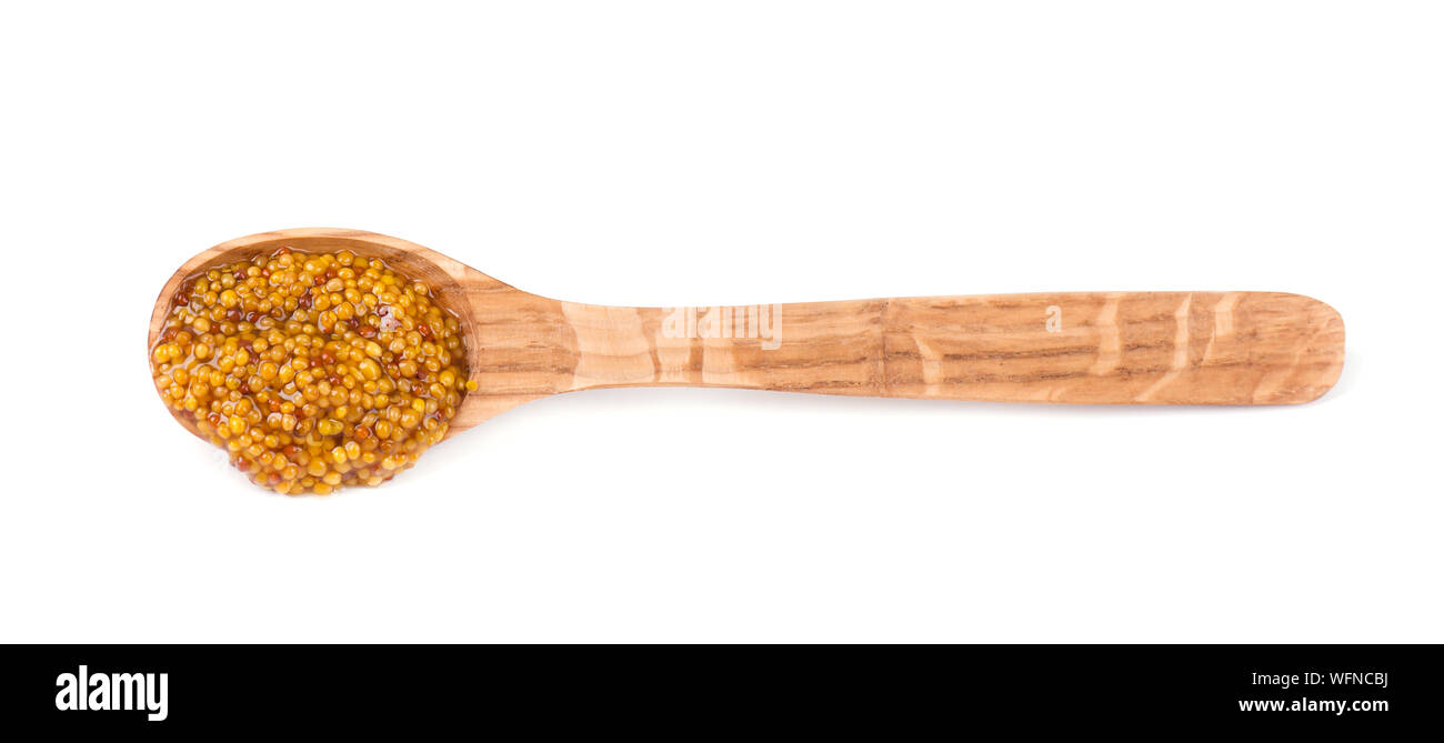Cucchiaio con Dijon deliziosa salsa mostarda isolati su sfondo bianco. La senape sul cucchiaio di legno isolato Foto Stock