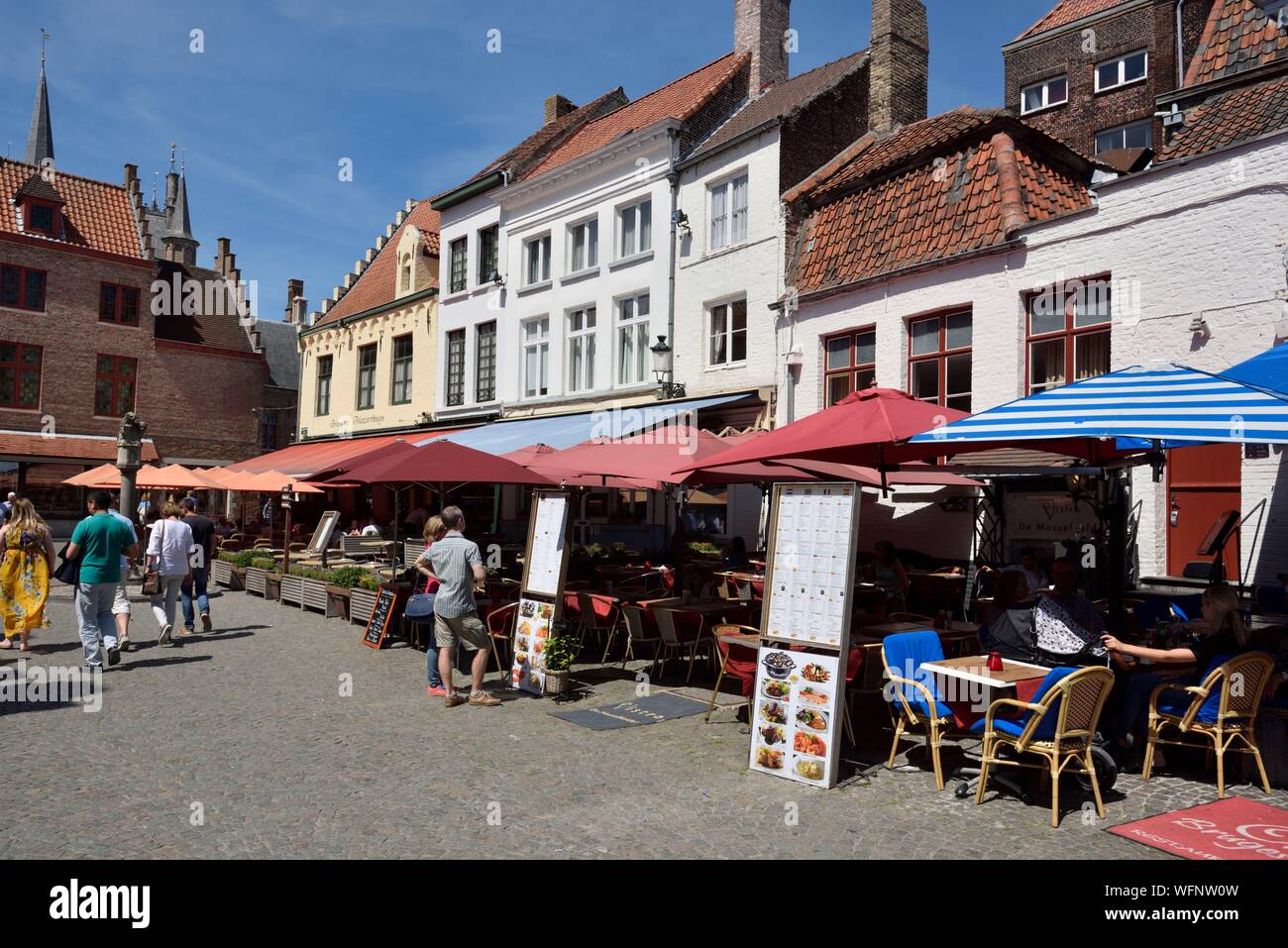 Belgio Fiandre Occidentali, Bruges, centro storico elencati come patrimonio mondiale dell UNESCO, Rosaire quay, Huidenvettersplein street, caffetterie ristoranti, giovane la lettura di un menu Foto Stock