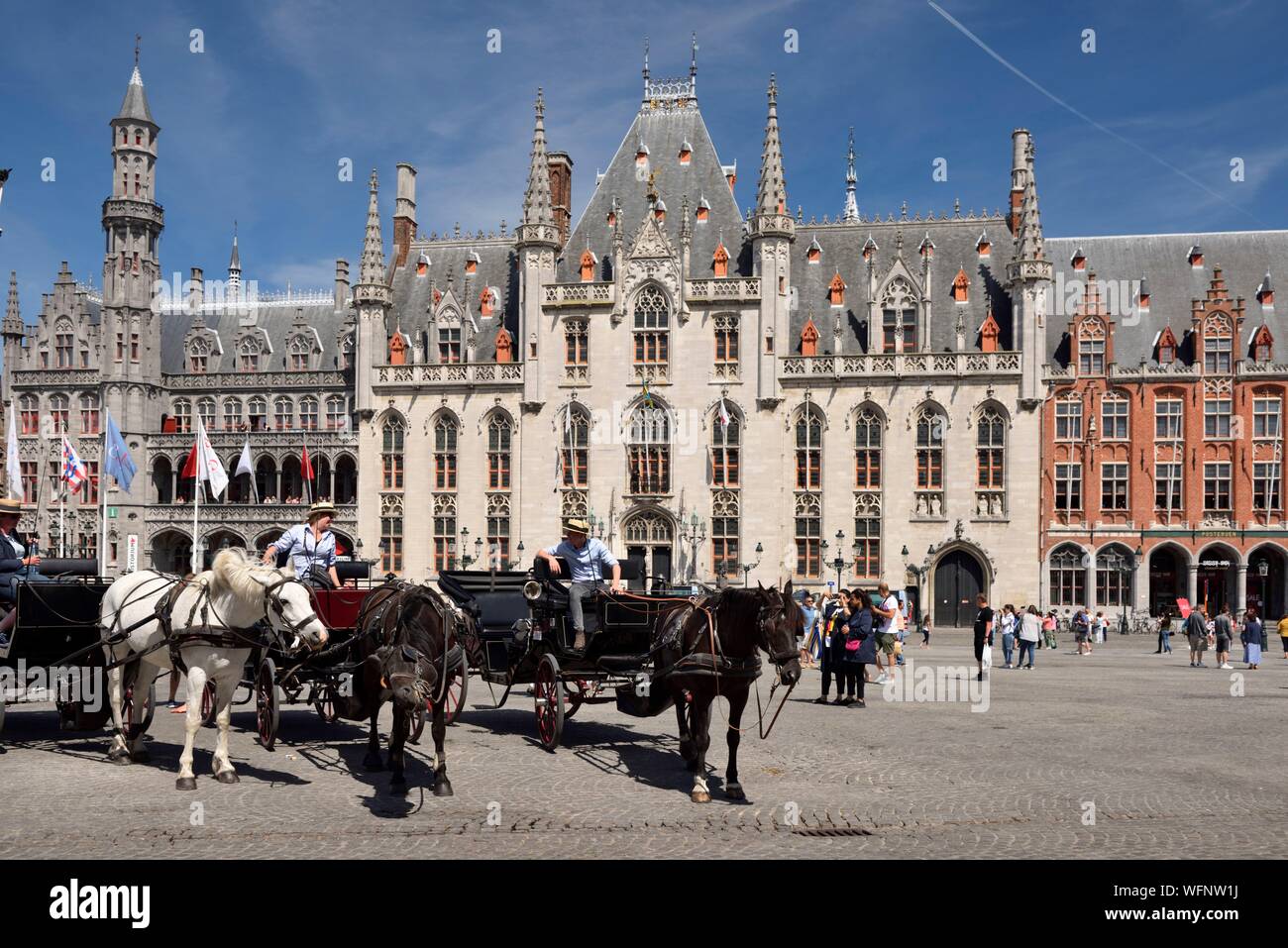 Belgio Fiandre Occidentali, Bruges, centro storico elencati come patrimonio mondiale dell UNESCO, Grand Place, carrelli scorrono i turisti di fronte al Provinciaal Hof o palazzo provinciale Foto Stock