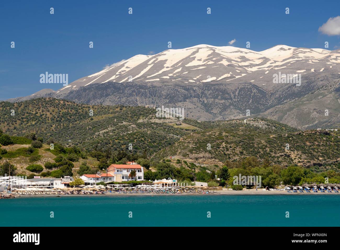 La Grecia, Creta Agia Galini, Paralia Agia Galini, spiaggia con Monte Ida (o montagna Psiloritis) salendo a 2,456 metri Foto Stock