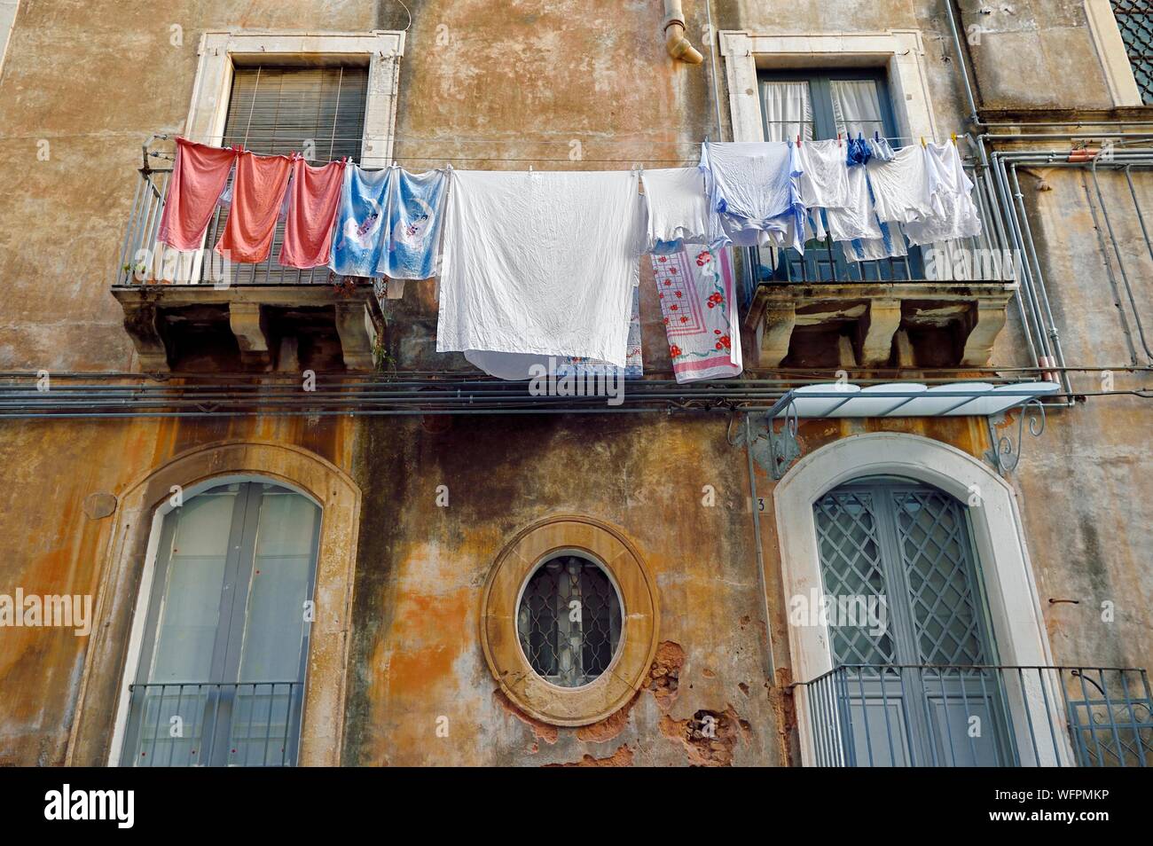 L'Italia, Sicilia, Catania, città barocca elencati come Patrimonio Mondiale dell'UNESCO, servizio lavanderia asciugatura sul balcone di un edificio nella città vecchia Foto Stock